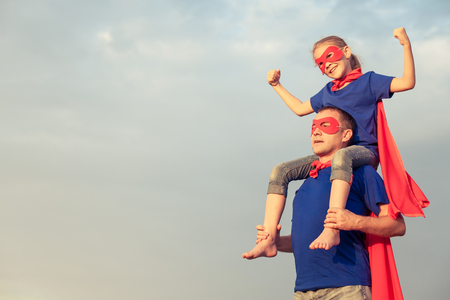 Father and daughter playing superhero at the day timeの写真素材