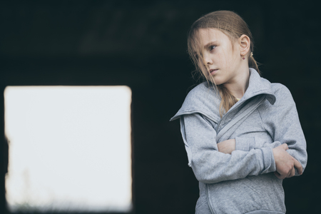 Portrait of sad little girl outdoors at the day time. Concept of sorrow.の写真素材