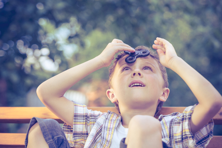 Happy little boy playing in the park at the day time. He playing with spinner. Kid having fun on the nature. Concept of happiness.の写真素材