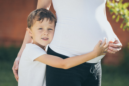 Happy little boy huging mother in the park at the day time.  They  having fun on the nature. Concept of happiness.の写真素材