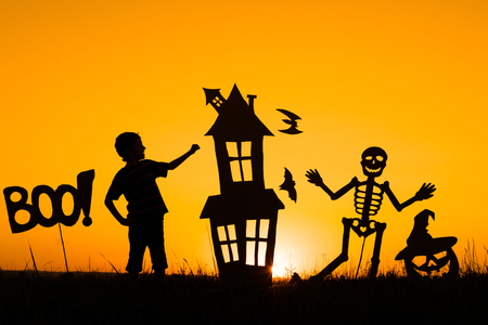 Happy little boy playing outdoors at the sunset time. Kid having fun. Concept of happy Halloween party.の写真素材