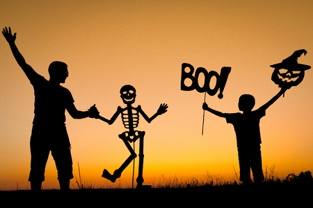 Happy father and son playing outdoors at the sunset time. People having fun. Concept of happy Halloween party.の写真素材
