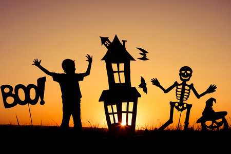 Happy little boy playing outdoors at the sunset time. Kid having fun. Concept of happy Halloween party.の写真素材
