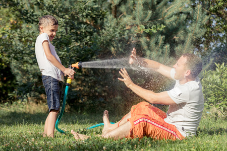 Happy father and son playing in the garden at the day time. People having fun oudoors. Concept of happy family.の写真素材