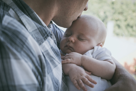 Father holding newborn baby son at the day time. Concept of happy family.の写真素材