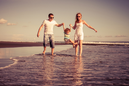 Happy family walking on the beach at the day time. Concept of friendly family on vacation.の写真素材