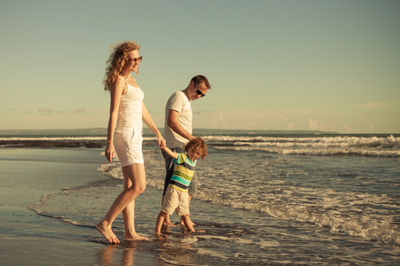 Happy family walking on the beach at the day time. Concept of friendly family on vacation.の写真素材