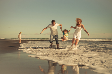 Happy family walking on the beach at the day time. Concept of friendly family on vacation.の写真素材