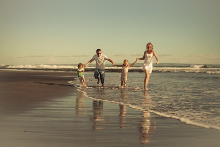 Happy family walking on the beach at the day time. Concept of friendly family on vacation.の写真素材