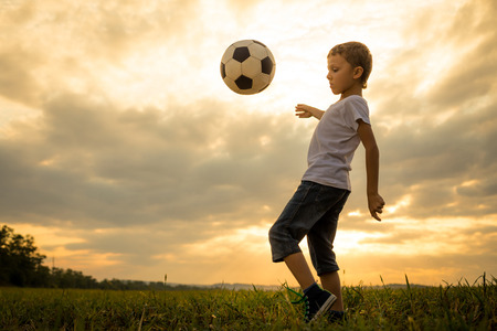 Young little boy playing in the field  with soccer ball. Concept of sport.の写真素材
