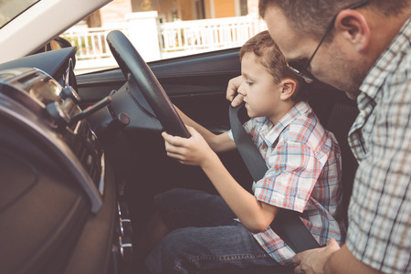 Happy father and son sitting in the car at the day time. People getting ready for road trip. Concept of happy family.の写真素材