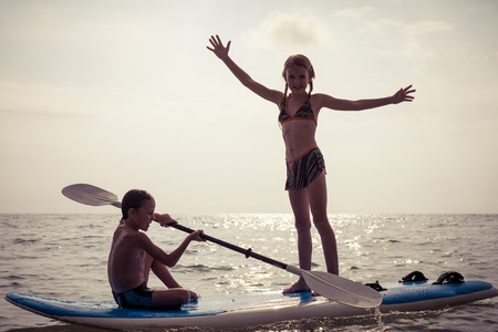 Happy children playing on the beach at the day time.Two Kids having fun outdoors. Concept of summer vacation and friendly family.の写真素材