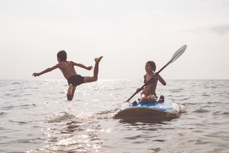 Happy children playing on the beach at the day time.Two Kids having fun outdoors. Concept of summer vacation and friendly family.の写真素材