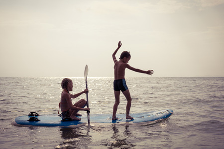 Happy children playing on the beach at the day time.Two Kids having fun outdoors. Concept of summer vacation and friendly family.の写真素材
