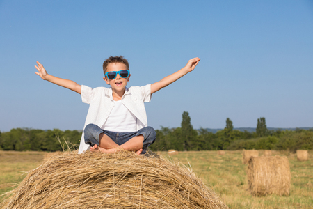 Happy little boy playing  in the park at the day time. Kid having fun outdoors. Concept of summer vacation.の写真素材
