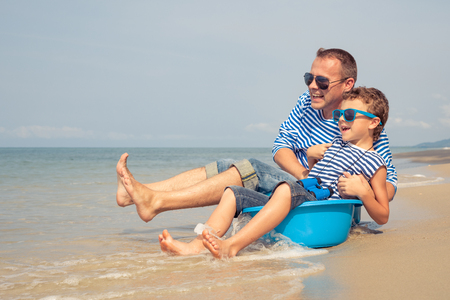 Father and  son playing on the beach at the day time. People having fun outdoors. Concept of summer vacation and friendly family.の写真素材