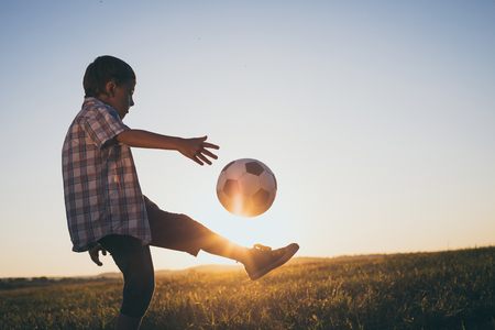 Young little boy playing in the field  with soccer ball. Concept of sport.の写真素材