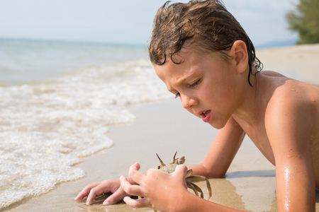 One happy little boy playing on the beach at the day time.  Kid having fun outdoors. Concept of summer vacation.の写真素材