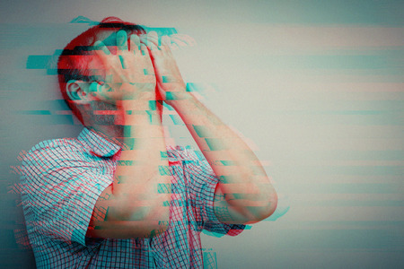 Portrait of a one sad man standing outdoors near the house at the day time. Concept of sadness. Glitched style photo.の写真素材