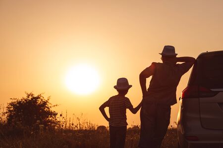 Father and son playing in the park at the sunset time. People having fun on the field. Concept of friendly family and of summer vacation.の写真素材