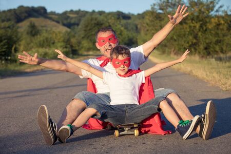 Father and son playing superhero at the day time. People having fun outdoors. Concept of friendly family.の写真素材