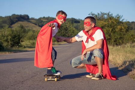 Father and son playing superhero at the day time. People having fun outdoors. Concept of friendly family.の写真素材