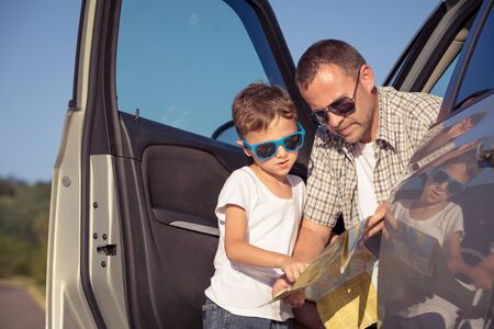 Happy father and son standing near the car at the day time. They look out the window. People having fun outdoors. Concept of the family is ready for travel.の写真素材