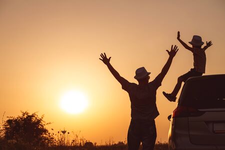 Father and son playing in the park at the sunset time. People having fun on the field. Concept of friendly family and of summer vacation.の写真素材
