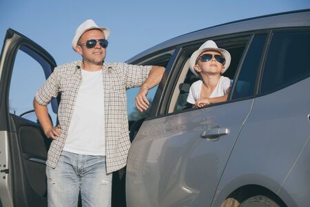 Happy father and son sitting in the car at the day time. They look out the window. People having fun outdoors. Concept of the family is ready for travel.の写真素材