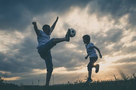 Father and young little boy playing in the field  with soccer ball. Concept of sport.の写真素材