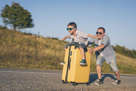 Father and son playing on the road at the day time. People having fun outdoors.  Concept of happy vacation and friendly family.の写真素材
