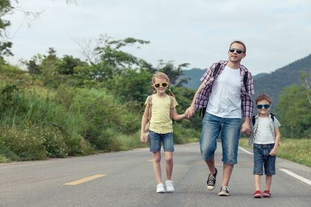 Father and children walking on the road at the day time.  Concept of friendly family.の写真素材