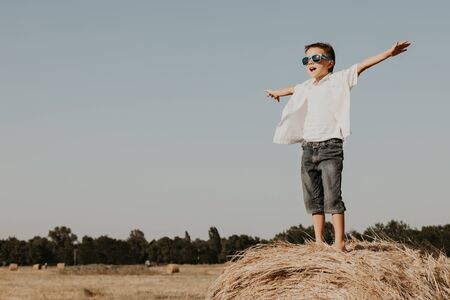 Happy little boy playing  in the park at the day time. Kid having fun outdoors. Concept of summer vacation.の写真素材