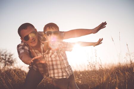 Father and son playing on the field at the day time. People having fun outdoors. Concept of friendly family.の写真素材
