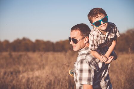 Father and son playing on the field at the day time. People having fun outdoors. Concept of friendly family.の写真素材