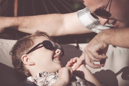 Father and son playing in the park at the day time. People having fun outdoors. Concept of summer vacation and friendly family.の写真素材