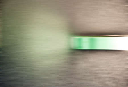 Blurred modern glass lamp illuminating grey textured wall with light on interior background, copy spaceの写真素材