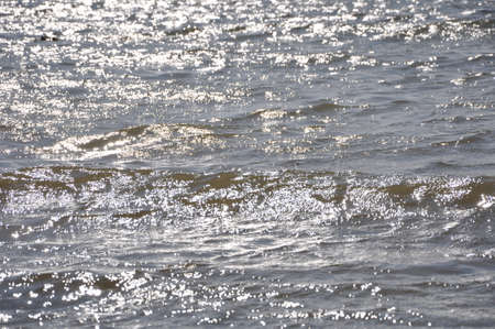 Beautiful blue water surface as a background texture with sun glareの写真素材