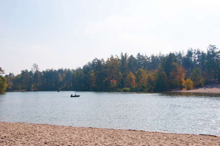 beautiful landscape of boat floating on lake or river water green autumn forest or wood and sunny sky in park outdoor on natural backgroundの写真素材