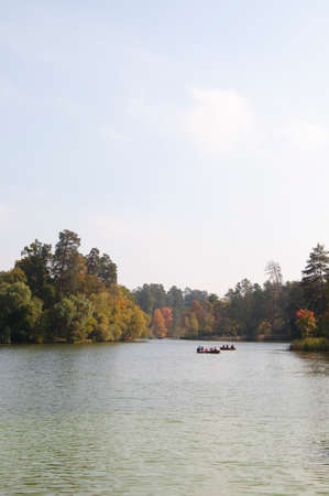 beautiful landscape of boat floating on lake or river water green autumn forest or wood and sunny sky in park outdoor on natural backgroundの写真素材