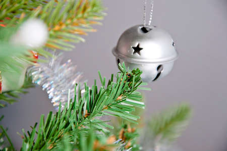 beautiful decorative xmas or new year ball bell silver color on green pine green christmas tree at holiday celebration decorationの写真素材