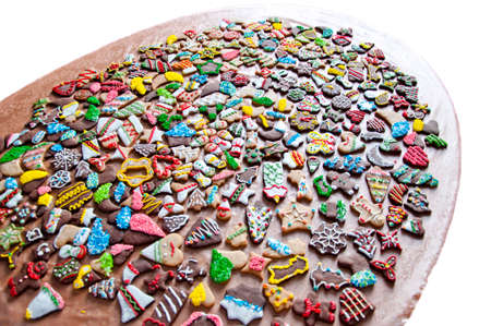 mix of many tasty christmas or xmas biscuits or cookies for new year with glaze and icing of colorful sprinkles on ginger baked pastry different shapes decorated laying on table isolated on whiteの写真素材