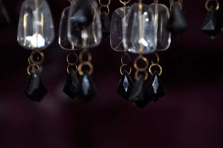 beautiful crystal or gemstones from plastic or glass white and black color on chain of chandelier lamp or lustre on blurred or defocused background, closeupの写真素材