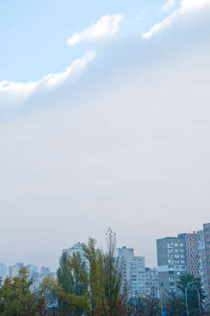 dark rainy cloud grey color above house roofs with green trees outdoor with blue sky at cityscapeの写真素材