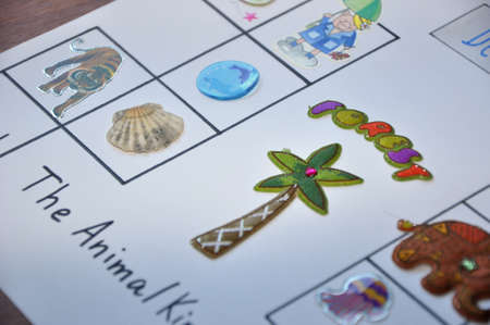 english lesson game on white paper with animal stickers and pictures for children education in school or kindergarten on tableの写真素材