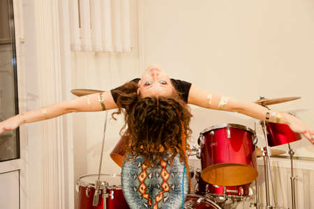 young cute sexy woman or girl with pocahontas ethnic tribal fashionable makeup on pretty face has feather in curly stylish long hair in indie cloth snake jeans and golden tattoo at drumsの写真素材