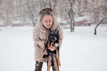 pretty cute young smiling girl or sexy woman in beige winter coat and camouflage military jeans...