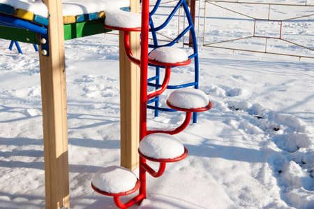 colorful children playground sunny outdoor in white winter season snow in street at cold christmas...