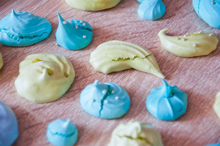 meringue top view background. sea shell dessert. trendy french cookies flat lay. green and blue color candy. whipped egg white sweets. marine mood with tasty meringues. silver luxury sprinkles pearlの写真素材
