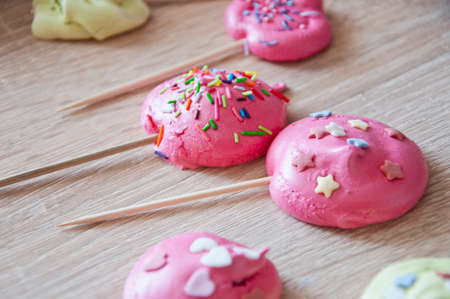 pink kiss french dessert meringues. pink dreams. sweet life concept with candy on sticks. showcase and sale in candy shop bar.の写真素材